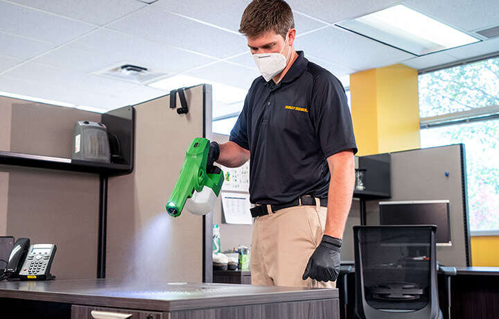Technician disinfecting with electrostatic sprayer