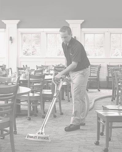 Stanley Steemer technician cleaning the carpet at a restaurant. 