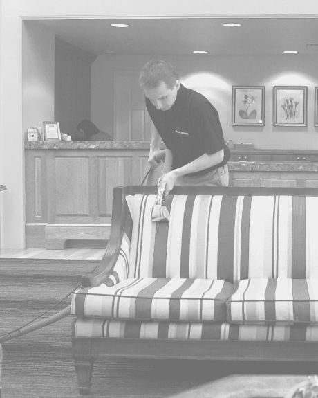 Stanley Steemer technician cleaning fabric upholstery in hotel lobby