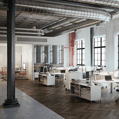 Desks inside industrial building with vents showing