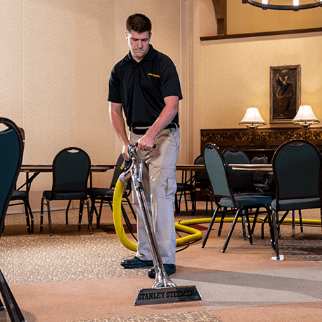 Stanley Steemer technician cleaning carpet in banquet hall
