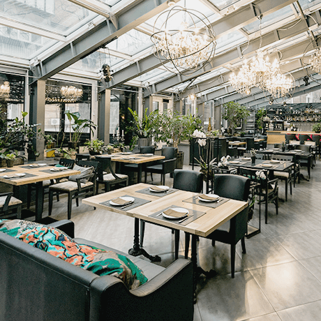 Restaurant with natural lighting, wood tables, and plants